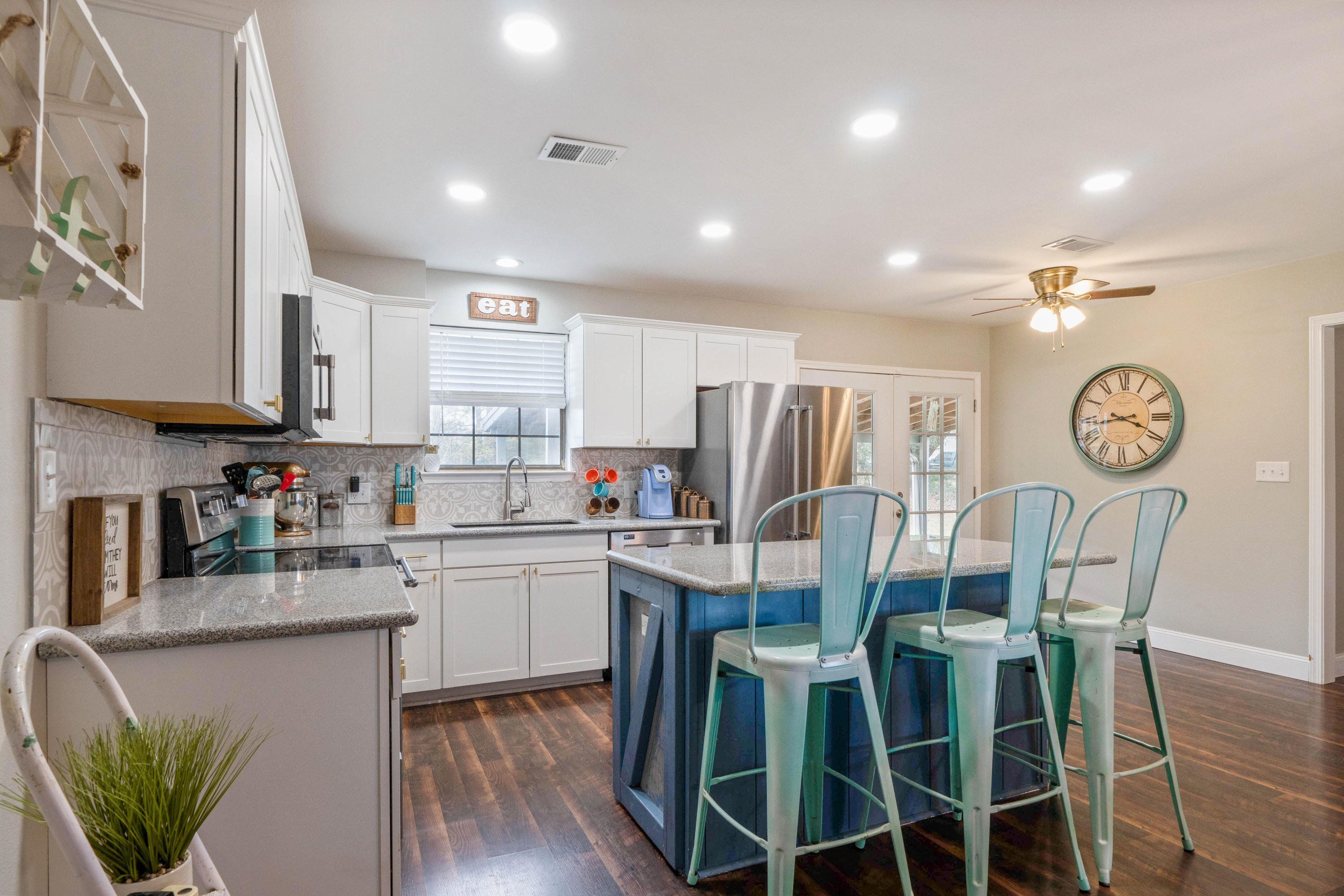 6086 Robin Road Crestview, FL 32539 - Photo 4 of 30 a kitchen with stainless steel appliances granite countertop a refrigerator a microwave oven a dining table and chairs with wooden floor