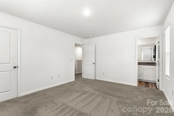 an empty room with closet and a bathroom