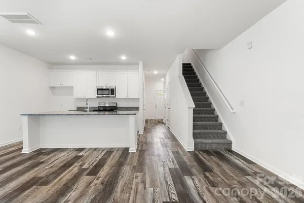 a view of kitchen with wooden floor and electronic appliances