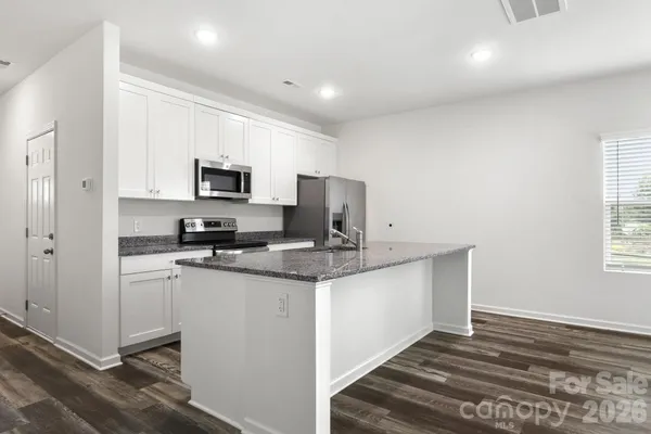 a kitchen with stainless steel appliances a sink stove refrigerator and a window