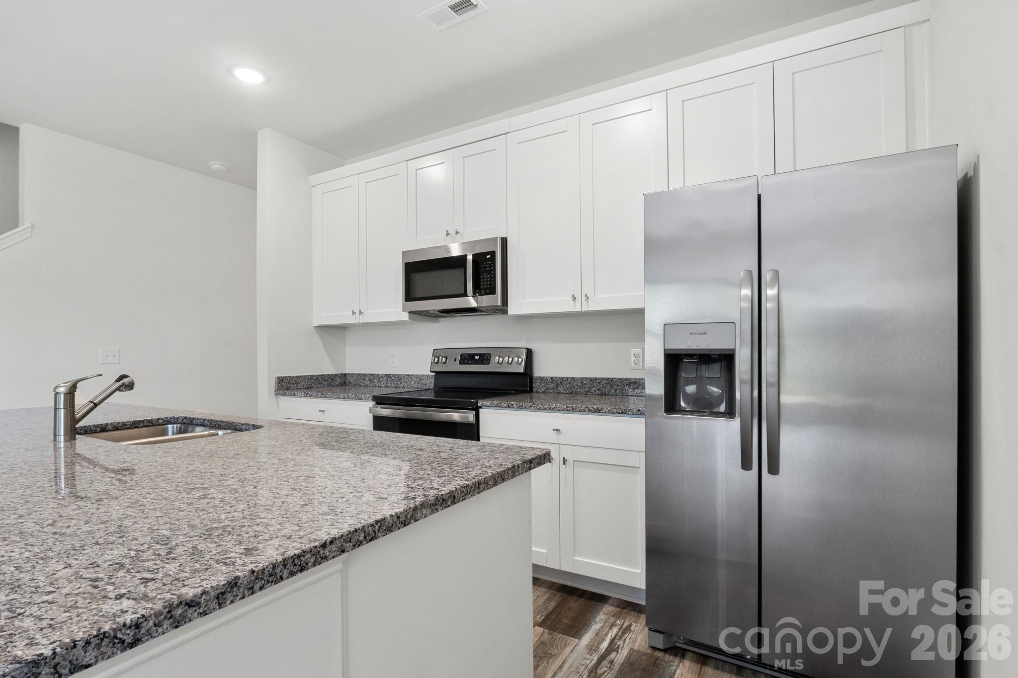 112 Angle Street Cherryville, NC 28021 - Photo 35 of 46 a kitchen with granite countertop a refrigerator a sink a stove and cabinets