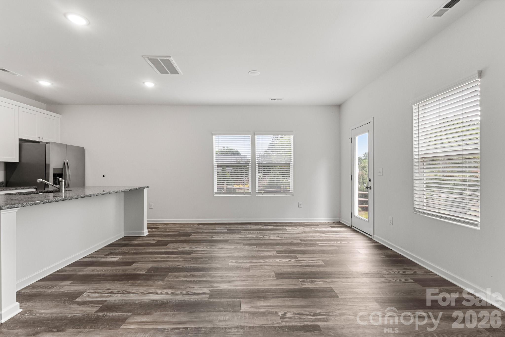 112 Angle Street Cherryville, NC 28021 - Photo 37 of 46 a view of a kitchen and an empty room with wooden floor and a window