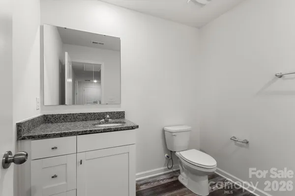 a bathroom with a granite countertop toilet and sink