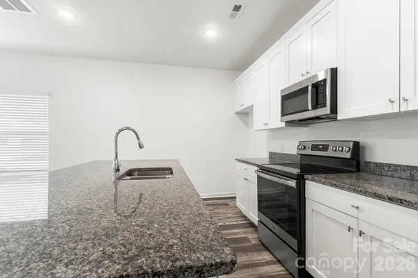 a kitchen with granite countertop a stove and a sink