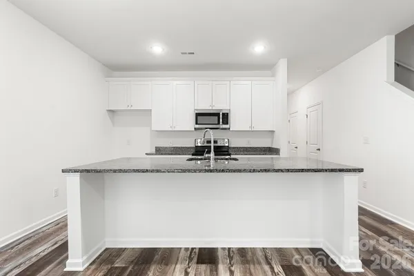 a kitchen with granite countertop a sink and a stove
