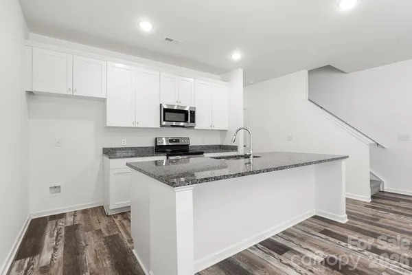 a kitchen with stainless steel appliances granite countertop a sink and a stove