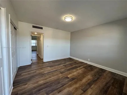 a view of an empty room and wooden floor