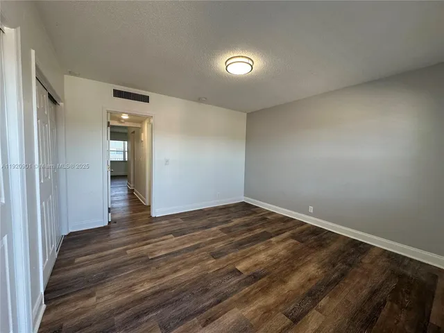 a view of an empty room and wooden floor