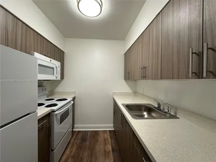 a kitchen that has a sink and a stove top oven