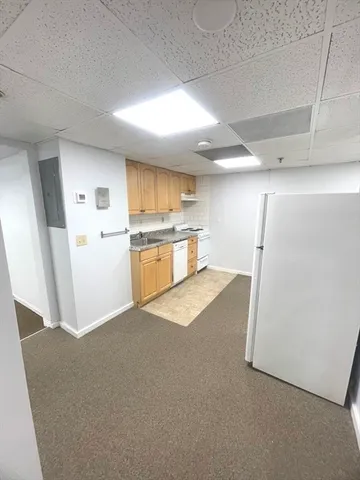 a kitchen with a refrigerator and a stove top oven