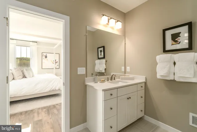 a en suite bathroom with a double vanity sink and a mirror