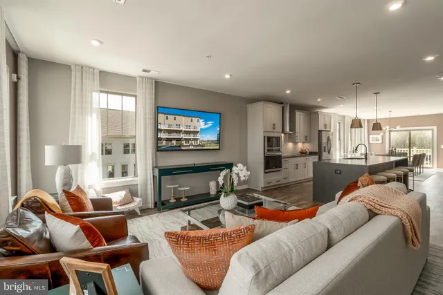a living room with furniture kitchen and a flat screen tv