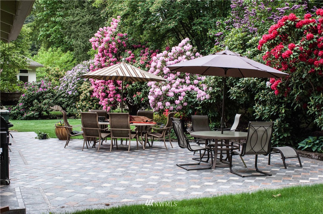 9302 Northeast 180th Street Bothell, WA 98011 - Photo 40 of 40 a view of a dining tables and chairs under an umbrella in backyard