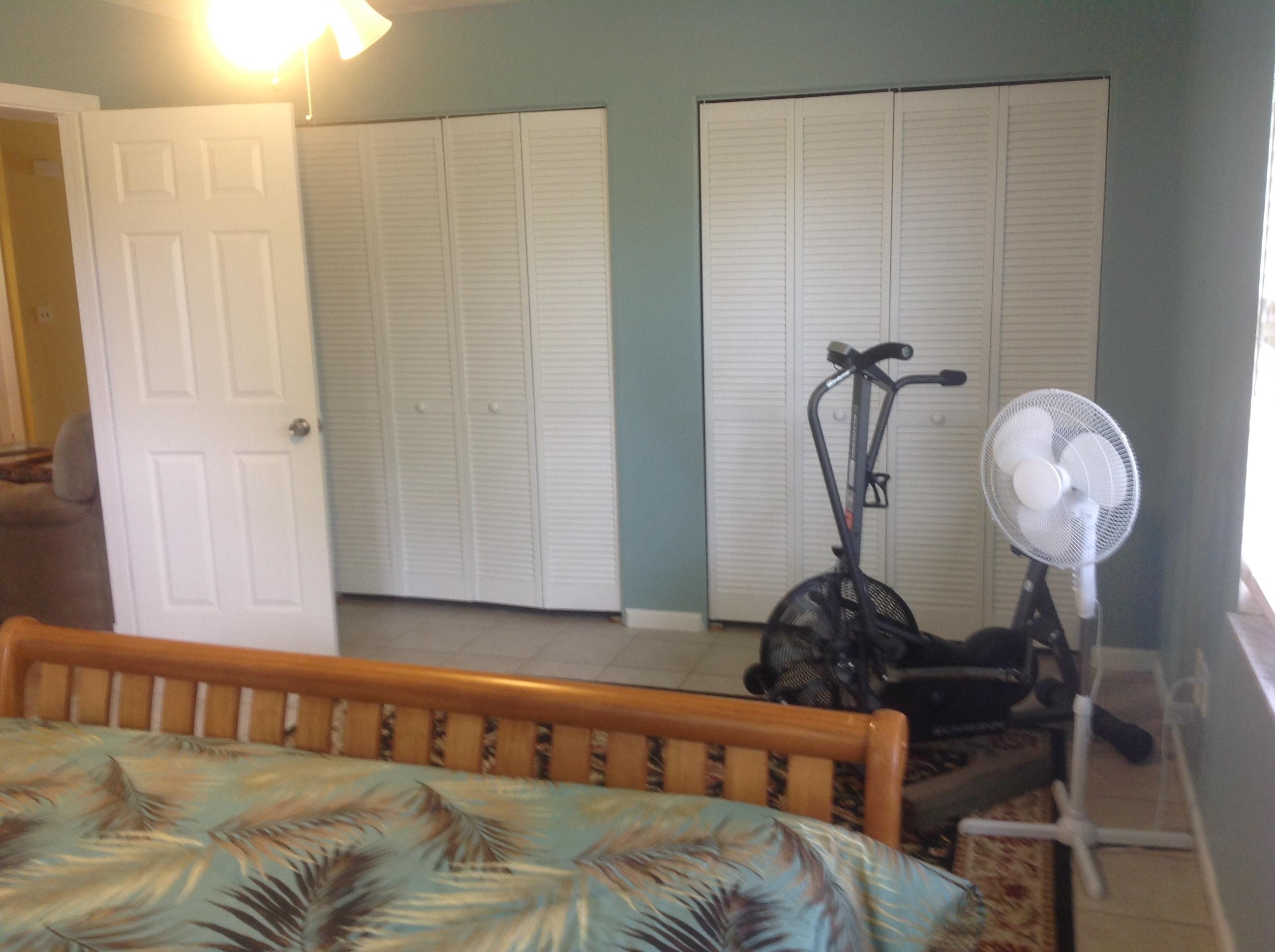 1545 Southeast Pitcher Road Port St. Lucie, FL 34952 - Photo 14 of 22 a bed sitting in a bedroom next to a window and a bathroom