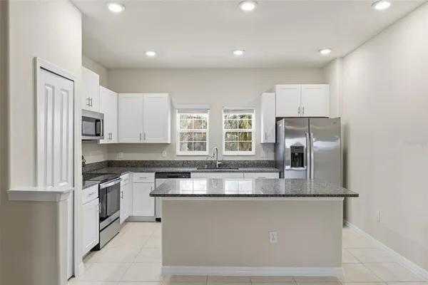 a kitchen with stainless steel appliances granite countertop a stove a sink and a refrigerator