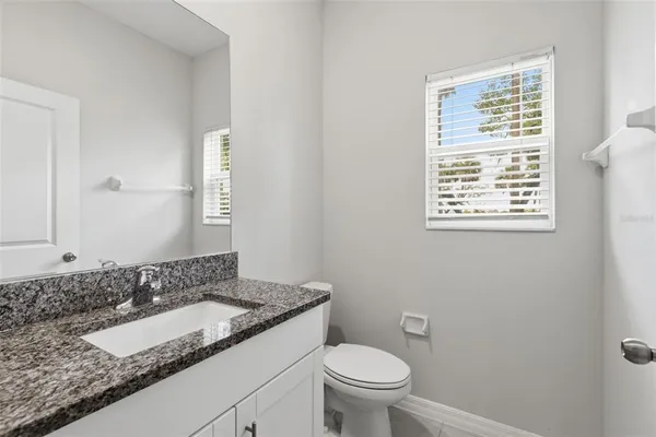 a bathroom with a granite countertop sink and a mirror