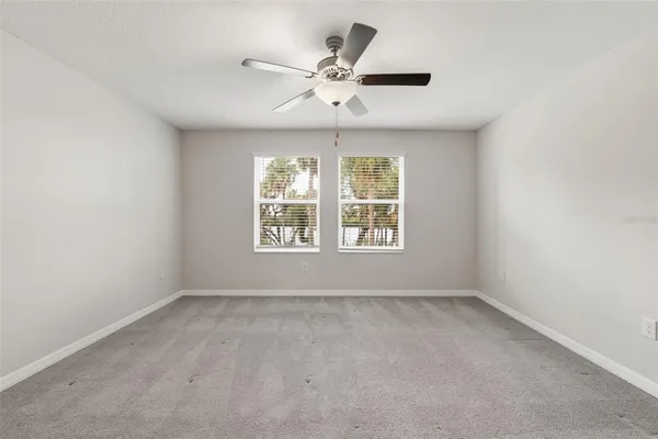 an empty room with a window and a ceiling fan