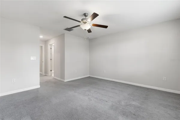 an empty room with chandelier fan