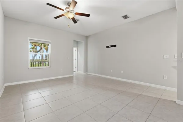 a view of an empty room and window chandelier fan