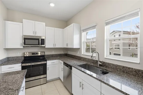 a kitchen with granite countertop a sink and a stove top oven