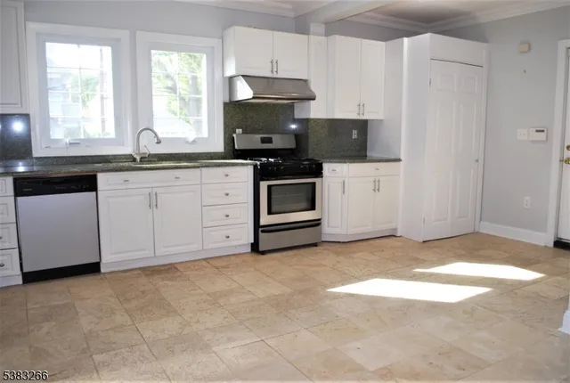a kitchen with granite countertop a stove a sink and a microwave