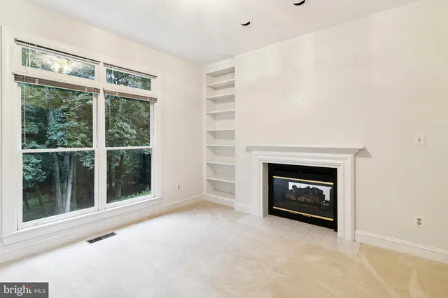 a view of an empty room with a fireplace and a window