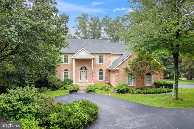 a front view of a house with a yard and trees