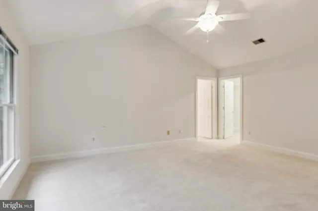 an empty room with a window and a fan