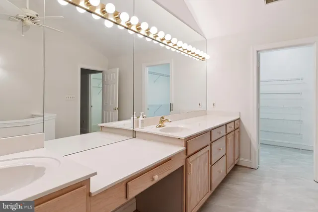 a en suite bathroom with a double vanity sink and a mirror