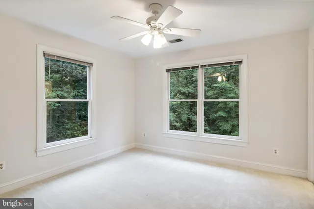 an empty room with a window and a fan