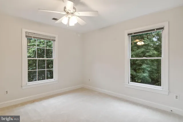 an empty room with a window and a fan