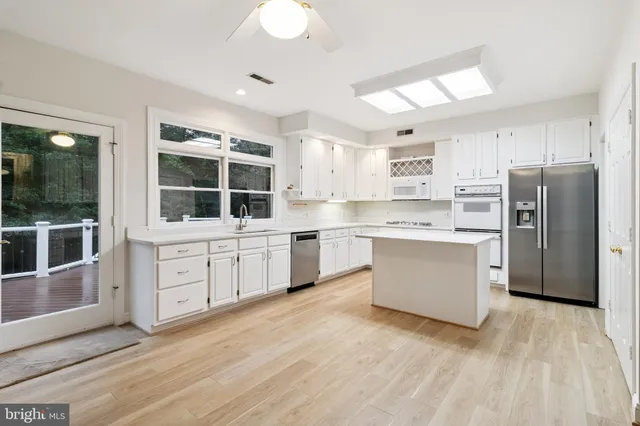 a kitchen with white cabinets and white appliances