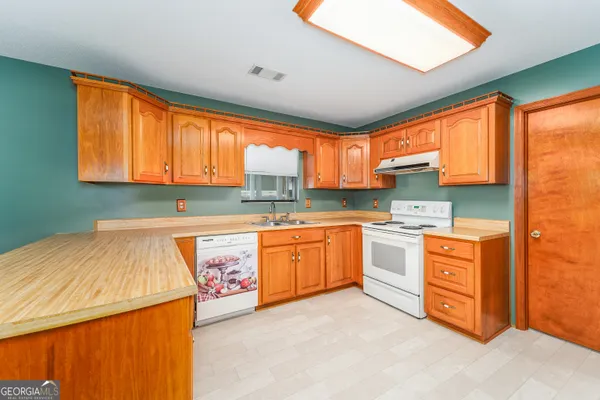 a kitchen with stainless steel appliances granite countertop a stove a sink and a refrigerator