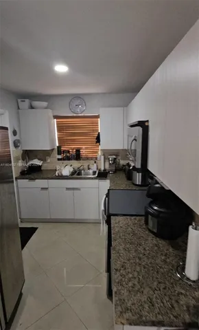 a bathroom with a granite countertop sink and a toilet