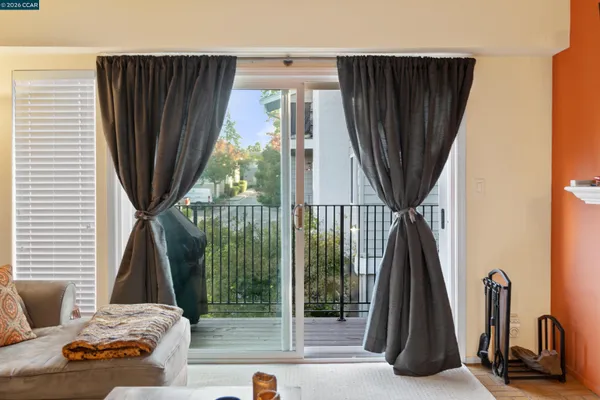 a living room with a floor to ceiling window and a wooden floor