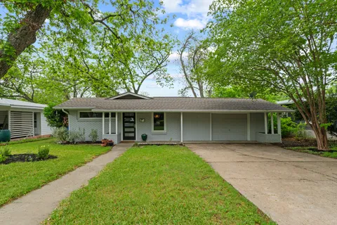 a front view of a house with a garden and yard