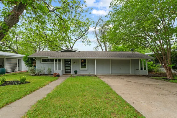 a front view of a house with a garden and yard