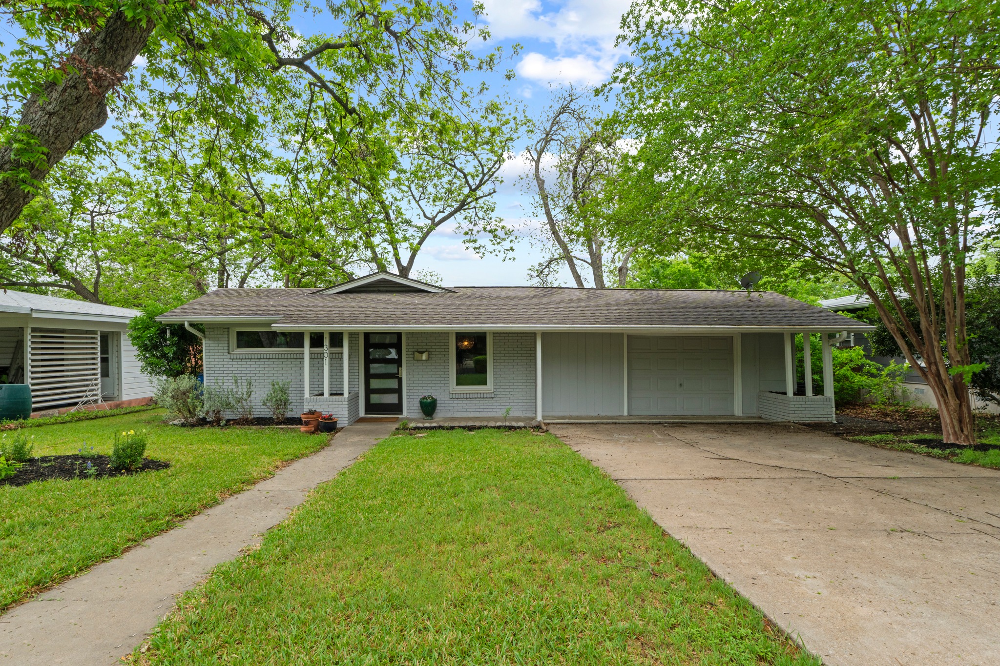 a front view of a house with a garden and yard