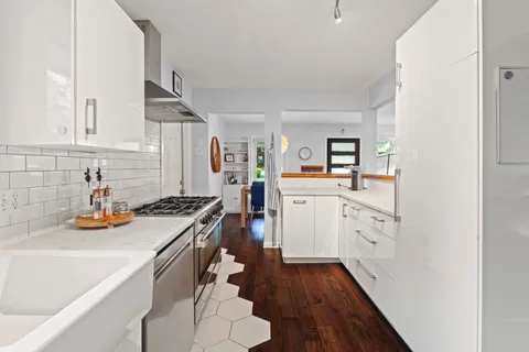 a kitchen with a sink a stove and cabinets