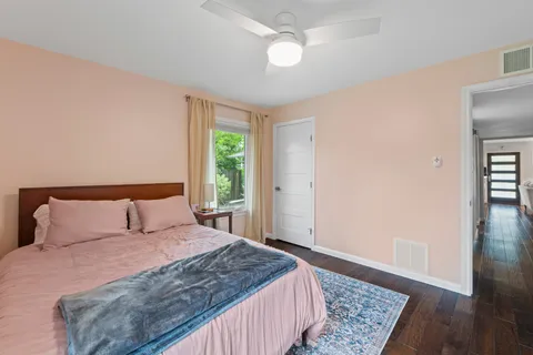 a bedroom with a bed and wooden floor