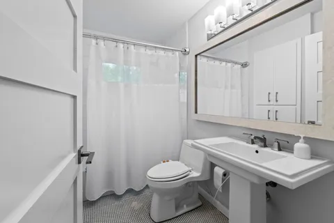 a bathroom with a sink a toilet and shower