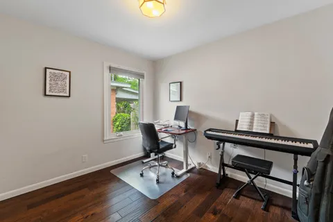 a view of a workspace with furniture and a window