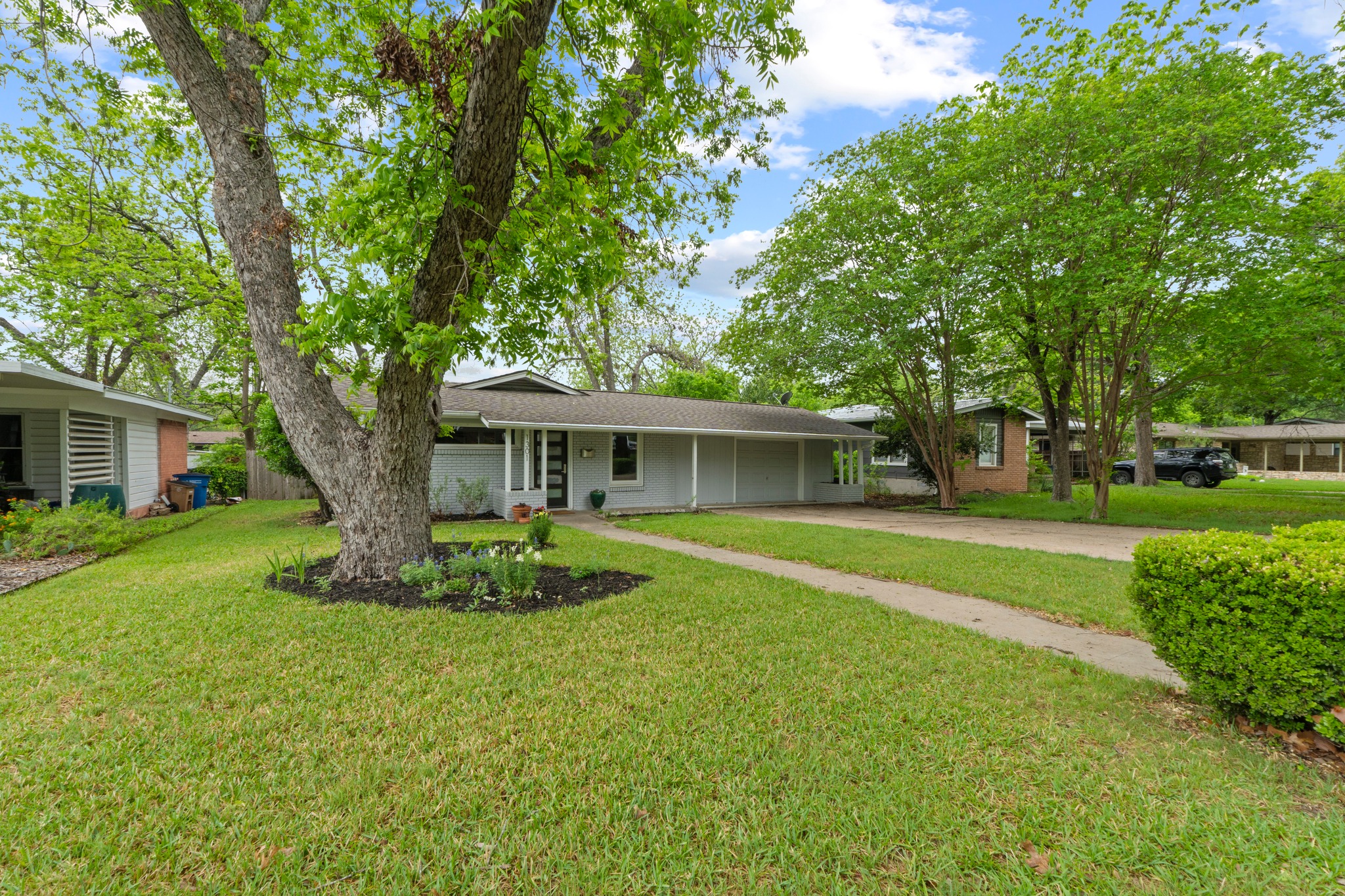 1301 Ridgemont Drive Austin, TX 78723 - Photo 8 of 32 a front view of a house with a garden