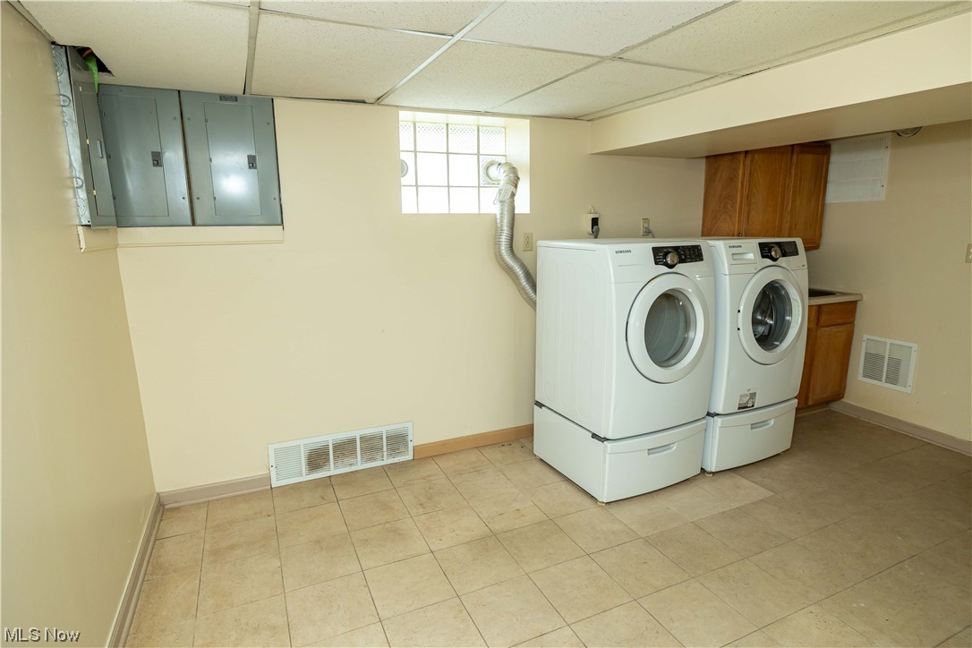 10105 Unity Avenue Cleveland, OH 44111 - Photo 22 of 35 Laundry area featuring light tile flooring, separate washer and dryer, and cabinets