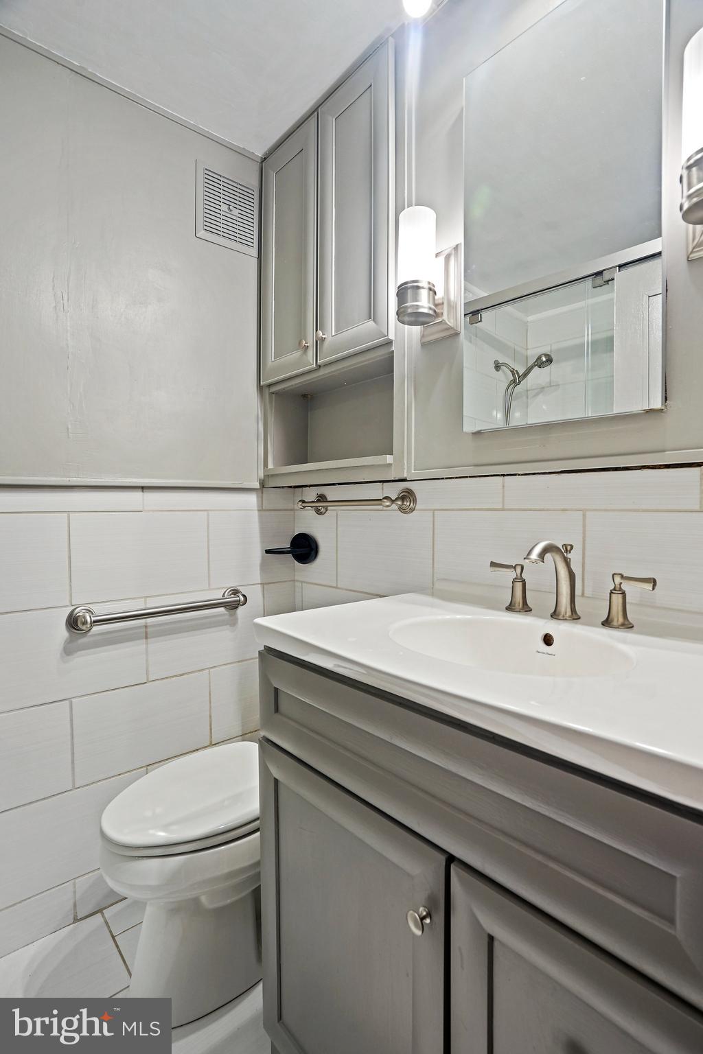 4740 Connecticut Avenue Northwest, Unit 404 Washington, DC 20008 - Photo 15 of 24 a bathroom with a sink a toilet and a mirror