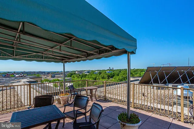 a view of a roof deck with dining table and chairs