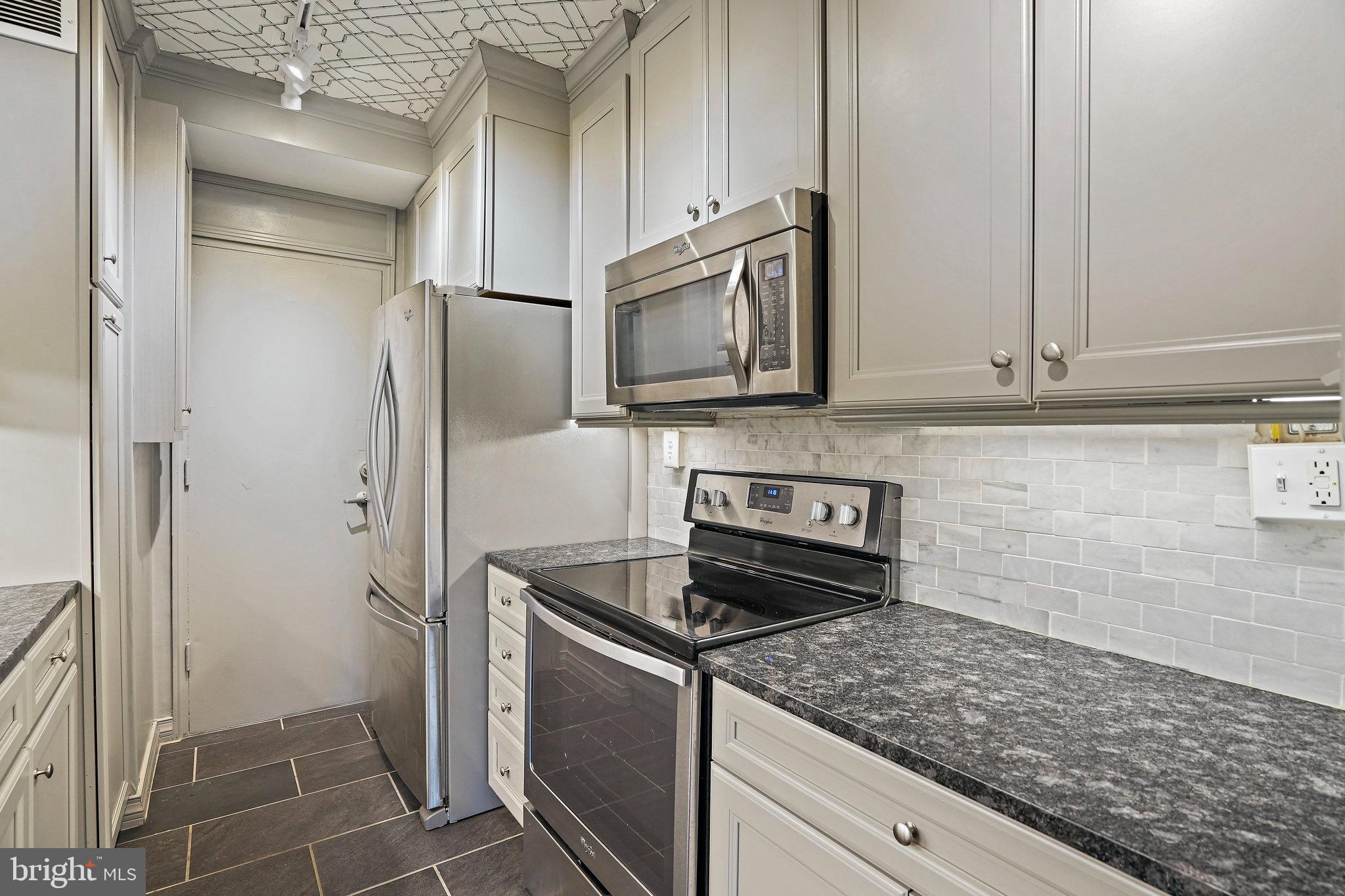 4740 Connecticut Avenue Northwest, Unit 404 Washington, DC 20008 - Photo 6 of 24 a kitchen with stainless steel appliances granite countertop a refrigerator and a stove