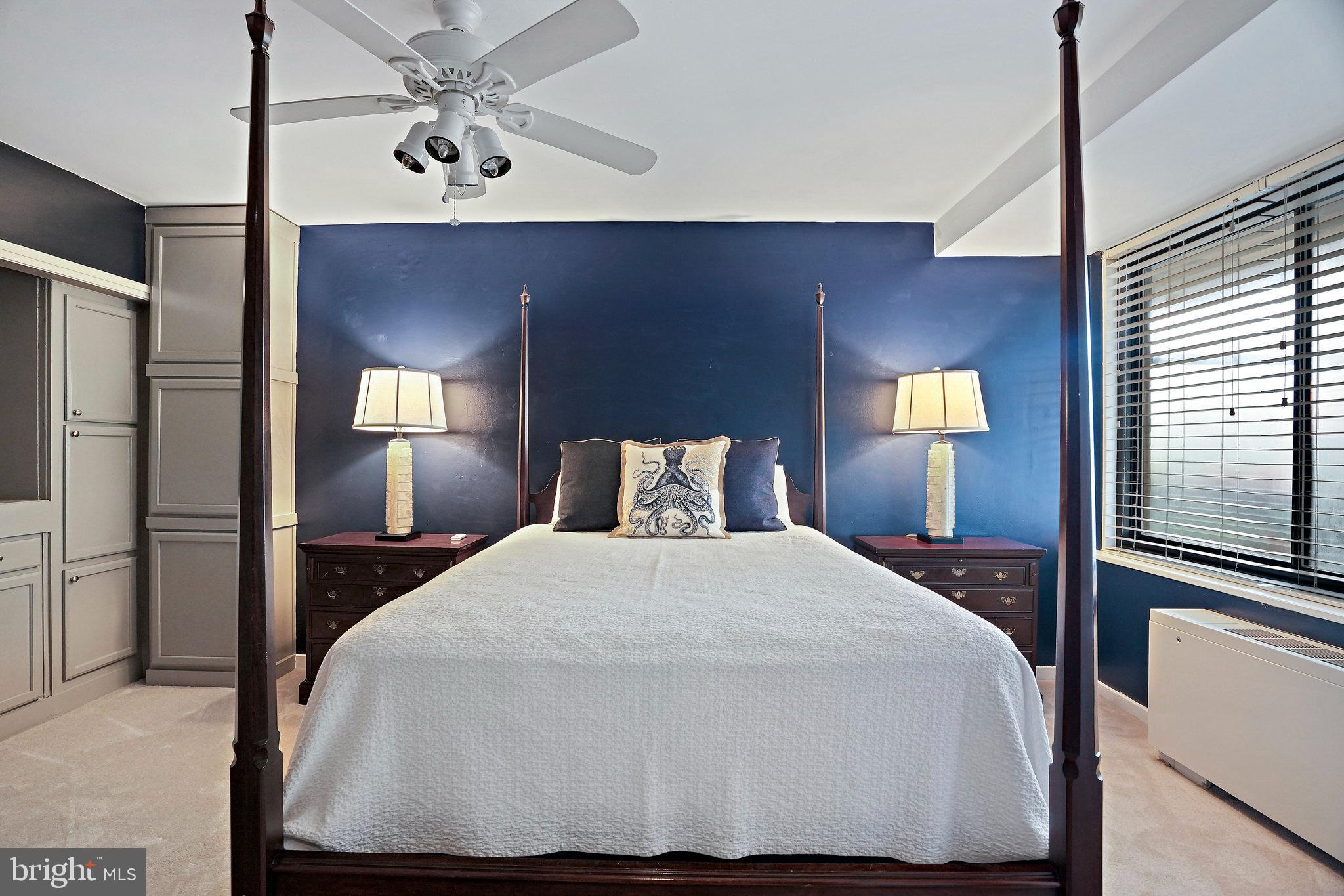 4740 Connecticut Avenue Northwest, Unit 404 Washington, DC 20008 - Photo 9 of 24 a bedroom with a bed and a chandelier