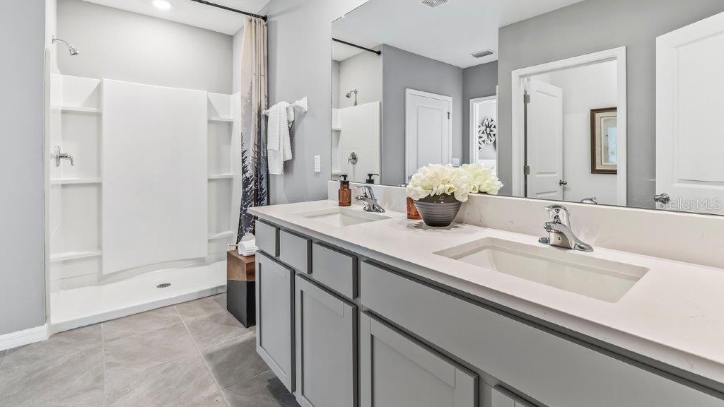 17811 Acorn Drop Road Land O Lakes, FL 34638 - Photo 8 of 11 a bathroom with a double vanity sink mirror and shower