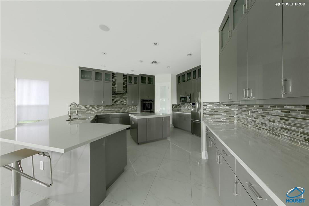 4524 Southwest 195th Way Miramar, FL 33029 - Photo 29 of 36 a kitchen with a sink and white cabinets